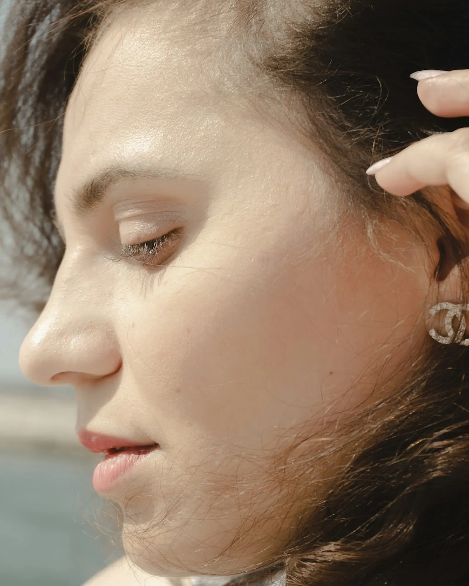 A woman resting her fingers against her jaw joint, just in front of the ear