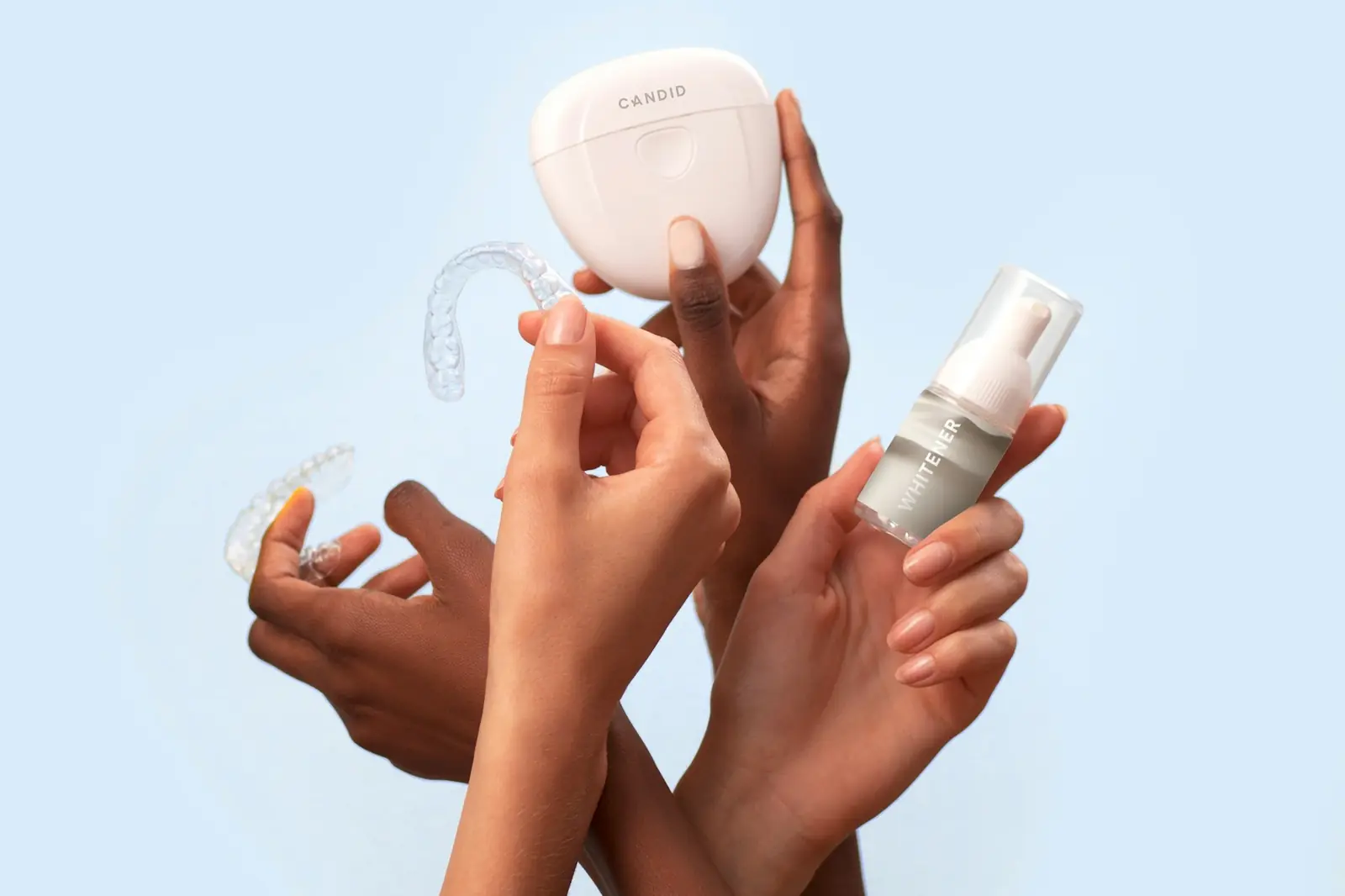 Clear orthodontic aligners held in an open hand beside their case